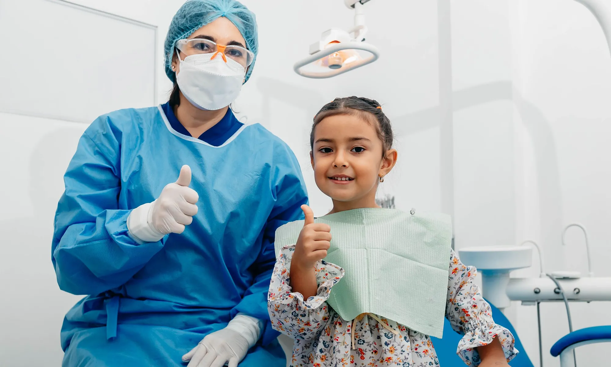 Una odontóloga y una niña sonriendo en el consultorio